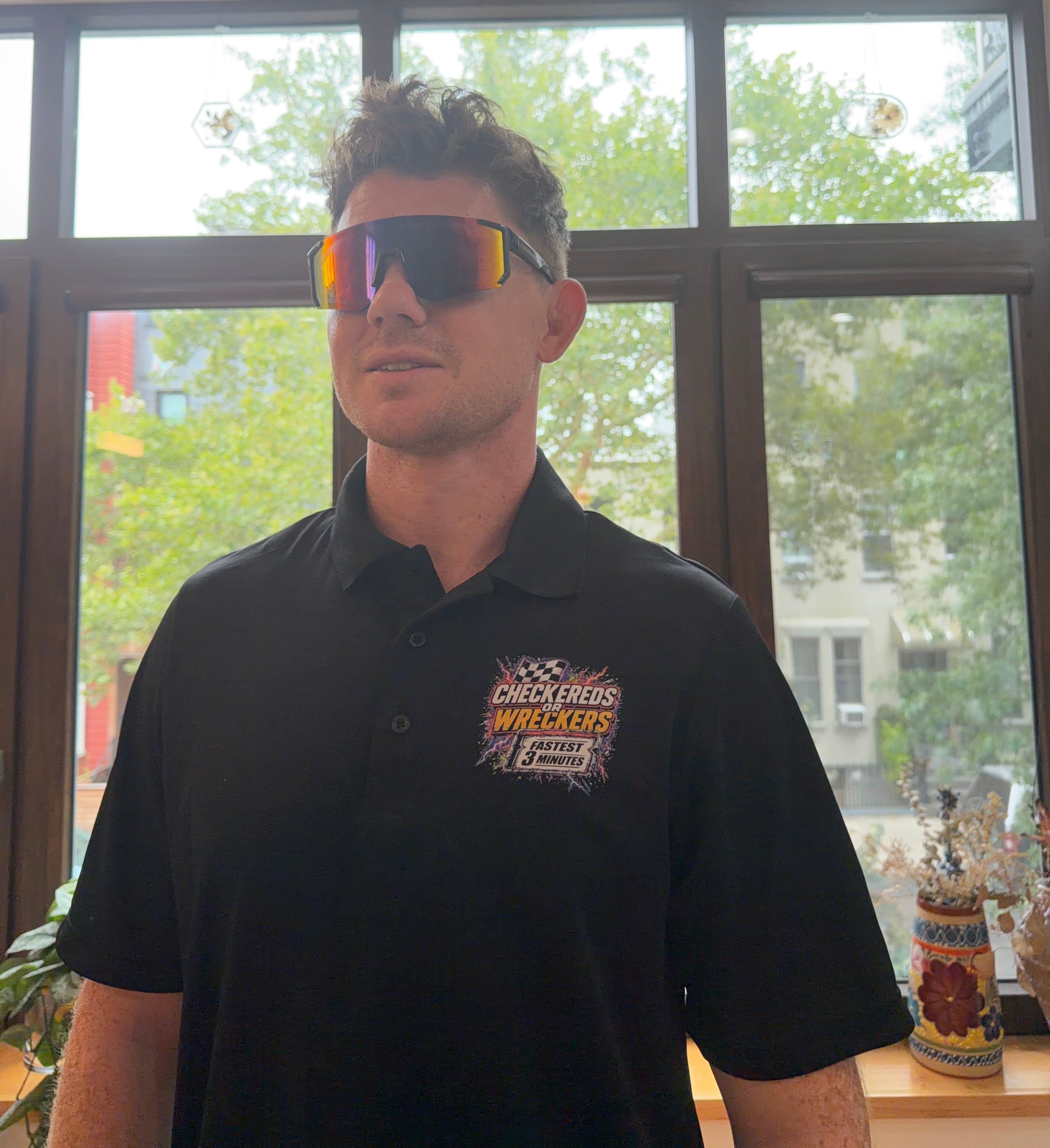 Checkereds or Wreckers black polo full front view with sunglasses