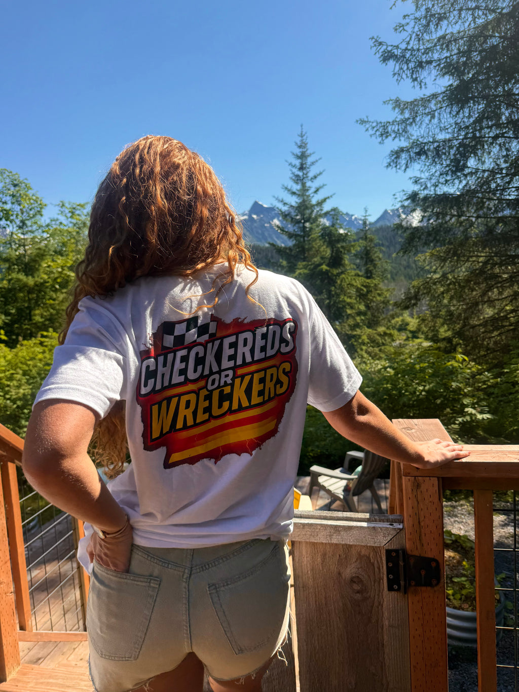 Checkereds or Wreckers white tee lifestyle shot on deck with mountain view