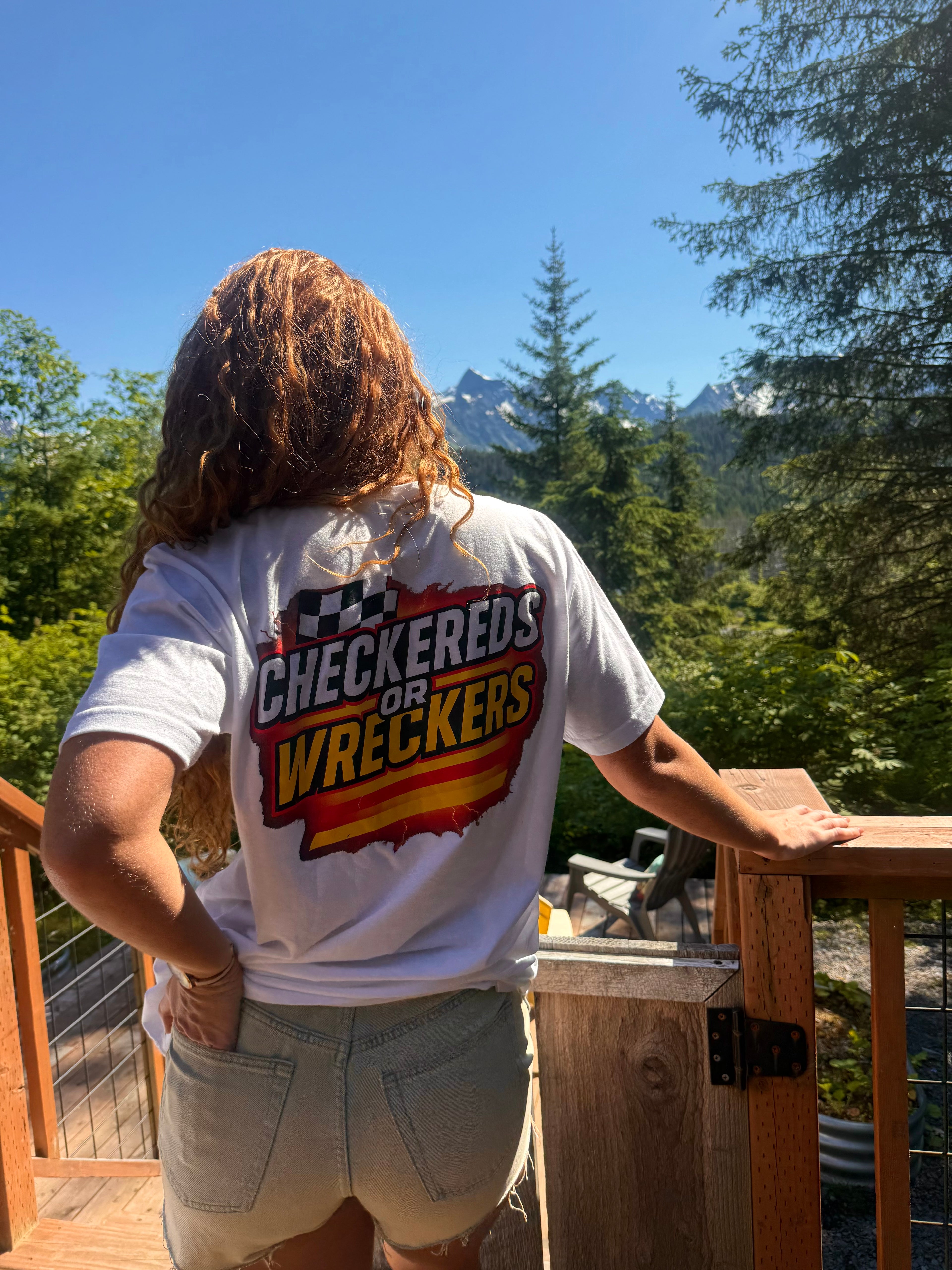 Checkereds or Wreckers white tee lifestyle shot on deck with mountain view